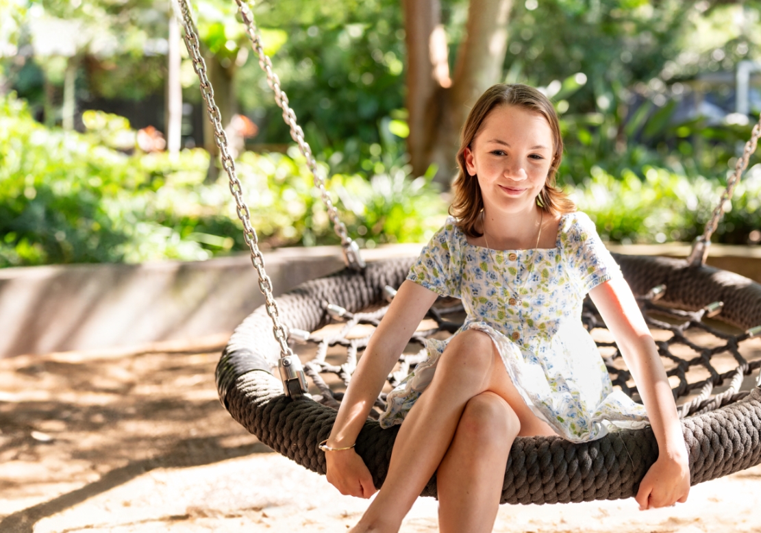 A young girl sits on a swing