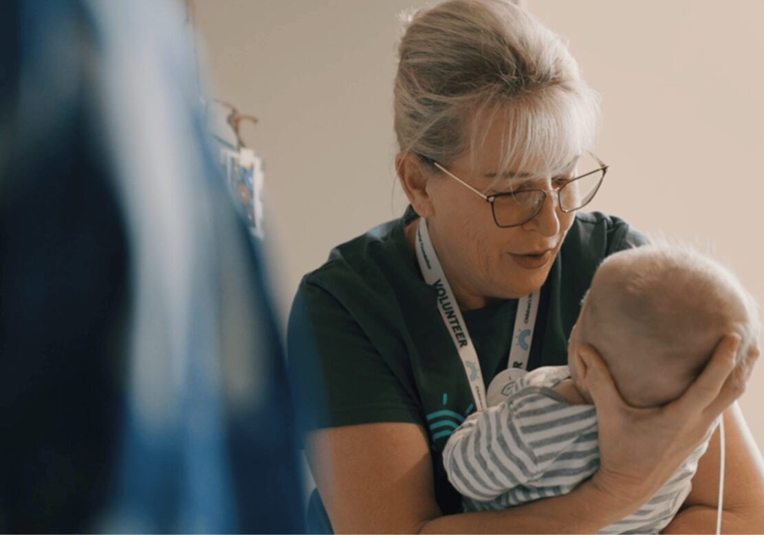 A Children's Hospital Foundation volunteer holds a young baby