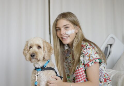 Patient holds Paw Play volunteer puppy during bedside visit