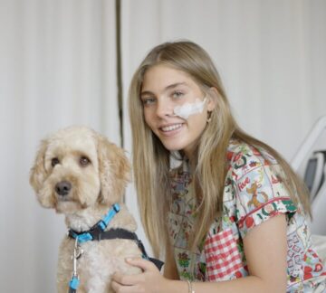 Patient holds Paw Play volunteer puppy during bedside visit