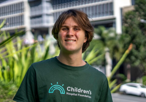 Max, former Queensland Children's Hospital patient, stands outside wearing Children's Hospital Foundation shirt