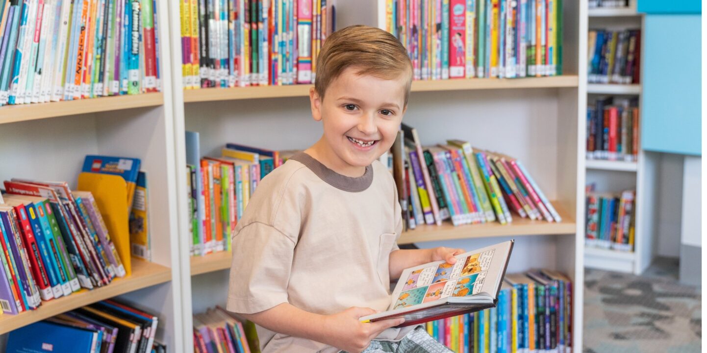 Ollie, 8, reading a book in Book Bunker