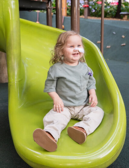 Lachlan sits on Queensland Children's Hospital playground slide