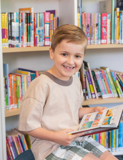 Ollie, 8, reading a book in Book Bunker