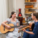 Lucy, 14, and music therapist play the guitar in music therapy session