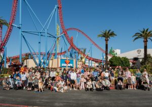 Families posing in front of Movie World on an excursion organised by Children's Hospital Foundation