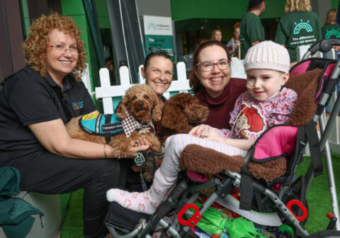 Young patient cuddles Paw Play support dogs during CHF's Families Week Foundation Fun Day