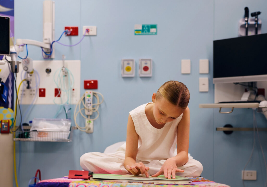 Evie, 12, draws a picture of home in a hospital room