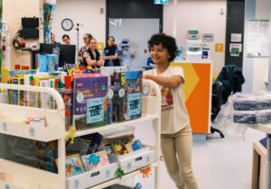 Myah pushes the new toy trolley she donated